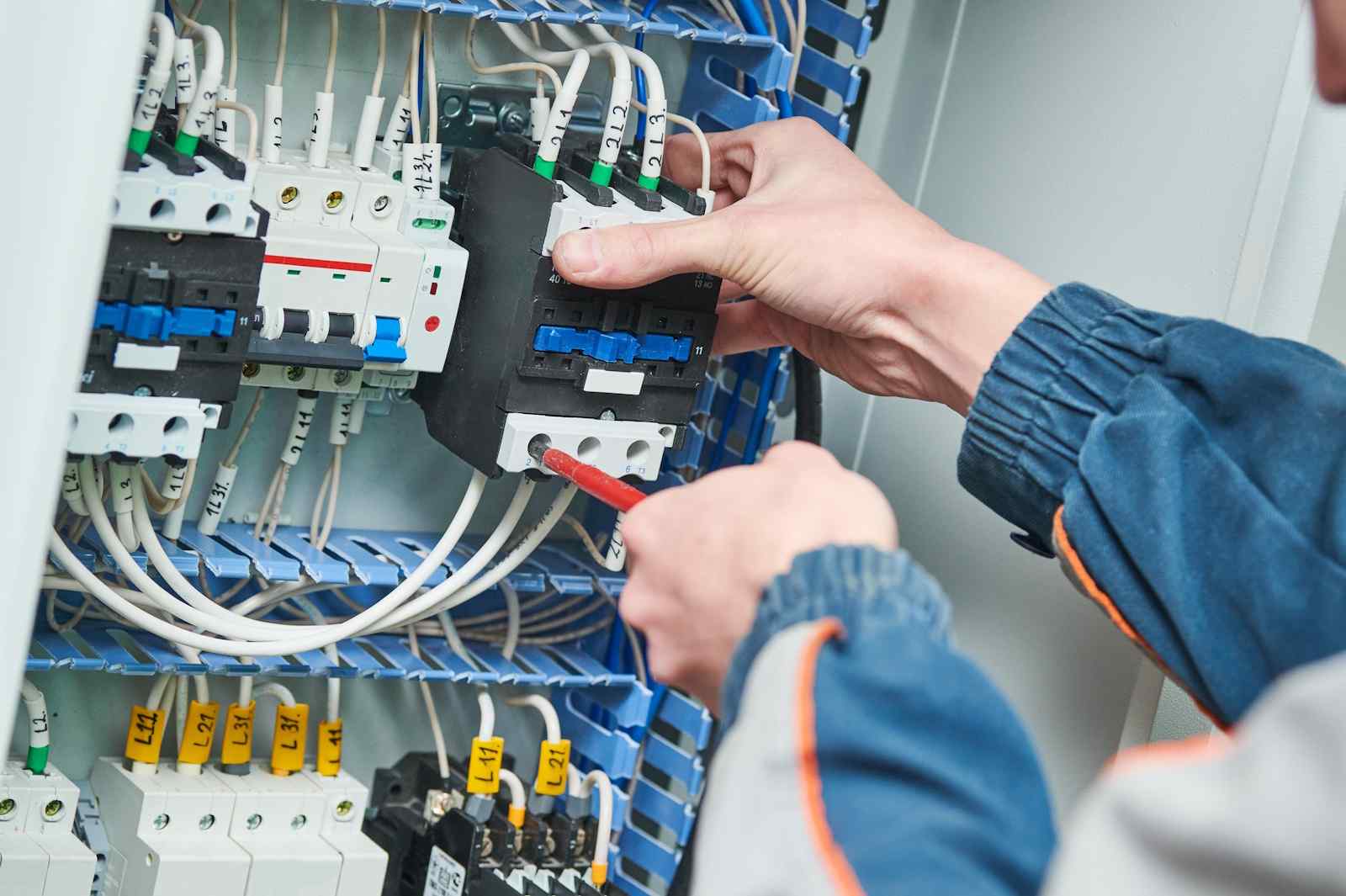 Electrician checking a breaker box for signs you need an electrical panel upgrade in Corona CA